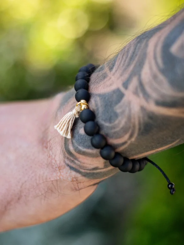 Pulseira “Equilíbrio de Preto” – Contas foscas, semibrilhantes e borla dourada